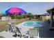 Backyard inground pool, umbrella, and chairs, perfect for relaxing at 474 Elm Nw Ave, Port Charlotte, FL 33952