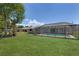 Expansive green backyard featuring a relaxing pool within a screened enclosure at 599 Encarnacion St, Punta Gorda, FL 33983