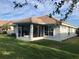 Beautiful backyard view featuring a screened patio and lush greenery at 6379 Grand Cypress Blvd, North Port, FL 34287