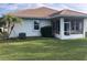 Lush backyard view featuring screened patio, an AC unit, and palm trees at 6379 Grand Cypress Blvd, North Port, FL 34287