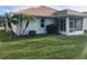 Well-maintained backyard with palm trees, an AC unit, and a screened patio at 6379 Grand Cypress Blvd, North Port, FL 34287