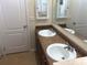 Bathroom boasts double sink vanity with wood cabinets and a large mirror at 6379 Grand Cypress Blvd, North Port, FL 34287