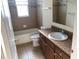 Bathroom features single sink vanity with wood cabinets and a tiled shower/tub at 6379 Grand Cypress Blvd, North Port, FL 34287