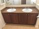 Bathroom vanity features double sinks, wooden cabinetry, and a large mirror at 6379 Grand Cypress Blvd, North Port, FL 34287