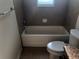 Bathroom features a white tub, toilet, and neutral tile at 6379 Grand Cypress Blvd, North Port, FL 34287