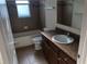 Bathroom showcases single sink vanity with wood cabinets and a tiled shower/tub at 6379 Grand Cypress Blvd, North Port, FL 34287