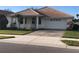Attractive single-story home showcasing a tidy lawn, tropical landscaping, and a convenient two-car garage at 6379 Grand Cypress Blvd, North Port, FL 34287