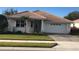 Inviting single-story home featuring a tile roof, well-kept lawn, and a two-car garage at 6379 Grand Cypress Blvd, North Port, FL 34287