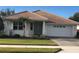Inviting single-story home featuring a tiled roof, a front-facing garage, and an easy-to-maintain lawn at 6379 Grand Cypress Blvd, North Port, FL 34287