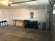 Spacious garage with ample storage, including a workbench, shelving, and recycling and trash bins at 6379 Grand Cypress Blvd, North Port, FL 34287
