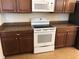 White oven situated among wood cabinets and brown granite countertops at 6379 Grand Cypress Blvd, North Port, FL 34287