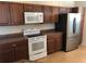 White oven situated among wood cabinets and stainless steel refrigerator at 6379 Grand Cypress Blvd, North Port, FL 34287