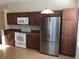 Well-lit kitchen with wooden cabinets, stainless steel refrigerator, and modern appliances, ready for home cooking at 6379 Grand Cypress Blvd, North Port, FL 34287