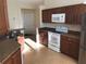 Updated kitchen with white appliances, wood cabinets, and tile flooring at 6379 Grand Cypress Blvd, North Port, FL 34287