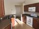 Kitchen with wooden cabinets, stainless steel sink, and modern white appliances including oven and microwave at 6379 Grand Cypress Blvd, North Port, FL 34287