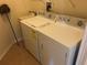 Functional laundry area features a white washer and dryer set, complemented by a utility sink at 6379 Grand Cypress Blvd, North Port, FL 34287