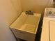 Close up on a plastic utility sink, located in the laundry room with a chrome faucet and basin insert at 6379 Grand Cypress Blvd, North Port, FL 34287