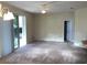Bright living room with carpet, ceiling fan, and sliding glass doors to outdoor area at 6379 Grand Cypress Blvd, North Port, FL 34287