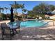 Community pool with comfortable lounge chairs and tropical landscaping at 6379 Grand Cypress Blvd, North Port, FL 34287