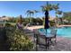Community pool with comfortable seating, surrounded by lush tropical landscaping at 6379 Grand Cypress Blvd, North Port, FL 34287