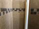 Shower stall with decorative tile, shower curtain, and silver fixtures at 6379 Grand Cypress Blvd, North Port, FL 34287