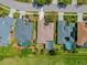 Aerial image of a property showcasing a backyard pool, lush landscaping, and neighborhood with similar backyard setups at 7344 Arrowhead Run, Lakewood Ranch, FL 34202