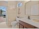 Well-lit bathroom with a single sink vanity, toilet, and view of the screened lanai and pool area at 7344 Arrowhead Run, Lakewood Ranch, FL 34202