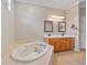 Bright bathroom featuring a soaking tub, double vanity, and decorative mirrors at 7344 Arrowhead Run, Lakewood Ranch, FL 34202