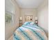 Small bedroom featuring a full bed with a patterned quilt, bedside lamps, and natural light at 7344 Arrowhead Run, Lakewood Ranch, FL 34202