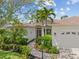 Beautiful home featuring manicured landscaping, a two-car garage, and a charming walkway to the front door at 7344 Arrowhead Run, Lakewood Ranch, FL 34202