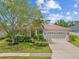 Charming single-story home featuring a two-car garage, lush landscaping, and a well-manicured lawn at 7344 Arrowhead Run, Lakewood Ranch, FL 34202