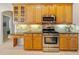 Kitchen showcases stainless steel appliances, tiled backsplash, and wood cabinetry at 7344 Arrowhead Run, Lakewood Ranch, FL 34202