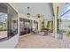 Covered lanai featuring brick flooring, comfortable seating, ceiling fan, and access to the outdoors through sliding glass doors at 7344 Arrowhead Run, Lakewood Ranch, FL 34202