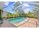 A beautiful backyard pool surrounded by a screened enclosure, brick patio, and lush landscaping at 7344 Arrowhead Run, Lakewood Ranch, FL 34202