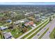 Drone shot of a neighborhood featuring a home with a white perimeter fence and other neighborhood residences at 8081 Dimstead St, Port Charlotte, FL 33981