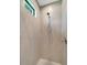 Modern bathroom featuring a tiled shower with a rainfall shower head and mosaic tile accent at 8081 Dimstead St, Port Charlotte, FL 33981
