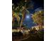 Backyard view at night with lush tropical landscaping, pool, and beautiful lighting at 95 N Marion Ct # 226, Punta Gorda, FL 33950
