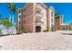 Beautiful low angle view of the building exterior with large tile parking area and some tropical landscaping at 95 N Marion Ct # 226, Punta Gorda, FL 33950