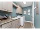 Laundry room with granite countertops, front load washer and dryer, and overhead cabinets at 95 N Marion Ct # 226, Punta Gorda, FL 33950