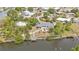 A waterfront property with a private dock, surrounded by lush greenery, seen from above at 103 Curtis Ne Ter, Port Charlotte, FL 33952