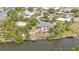 A waterfront property with a private dock, surrounded by lush greenery, seen from above at 103 Curtis Ne Ter, Port Charlotte, FL 33952