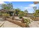 Landscaped backyard with pergola, garden beds, and lush greenery for a relaxing outdoor space at 103 Curtis Ne Ter, Port Charlotte, FL 33952