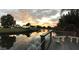 Relaxing canal-front backyard view showcasing water access, lush greenery, and a vibrant sunset at 103 Curtis Ne Ter, Port Charlotte, FL 33952