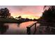 Lovely canal-front backyard view with peaceful water access, beautiful sunrise colors, and lush landscaping at 103 Curtis Ne Ter, Port Charlotte, FL 33952