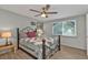 Bedroom featuring wood-look floors, ceiling fan, and unique decorative window at 103 Curtis Ne Ter, Port Charlotte, FL 33952