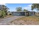 Charming single-story home with a covered carport and porch, complemented by a quaint blue door at 103 Curtis Ne Ter, Port Charlotte, FL 33952