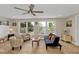 Bright living room featuring wood-look floors, comfortable seating and large windows with garden views at 103 Curtis Ne Ter, Port Charlotte, FL 33952