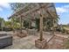 Charming outdoor patio featuring a pergola, dining table, and lush landscaping, perfect for entertaining and relaxation at 103 Curtis Ne Ter, Port Charlotte, FL 33952