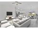 Bright, open-concept living room featuring contemporary furnishings, TV, and modern kitchen at 11456 5Th Ave, Punta Gorda, FL 33955
