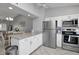 A modern kitchen featuring stainless steel appliances, white cabinets, and a granite countertop island at 1211 Saxony Cir # B5, Punta Gorda, FL 33983